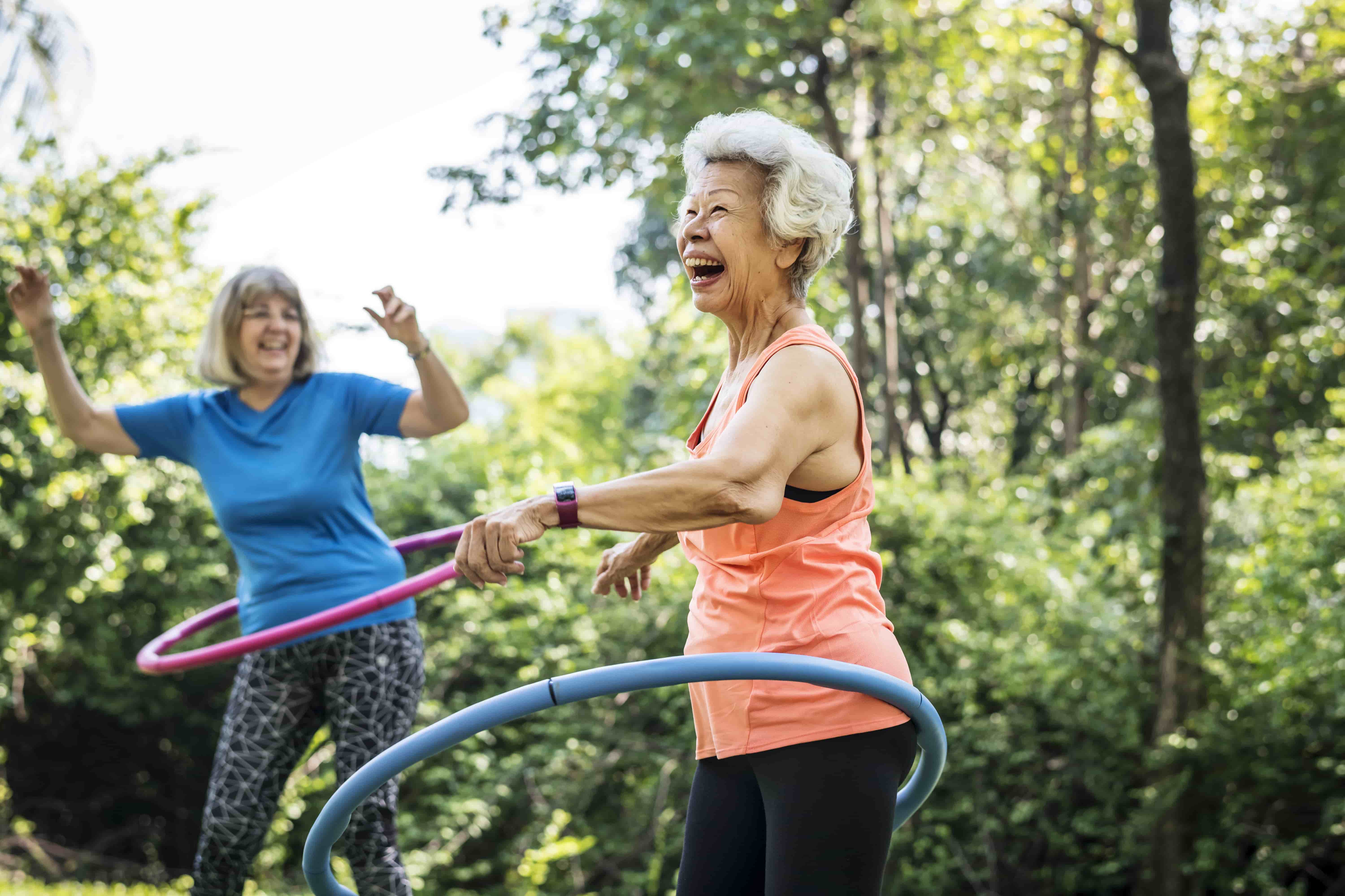 Two women hula hooping and laughing