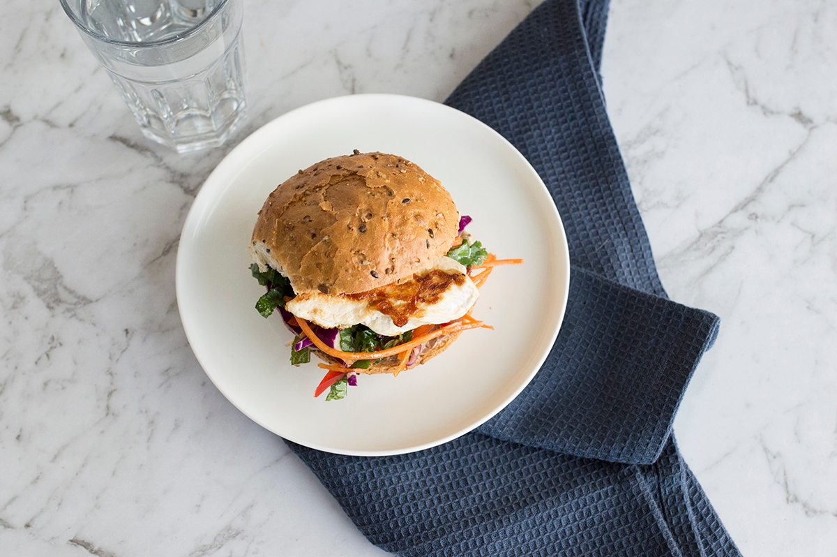 sandwich on a plate with a glass of water