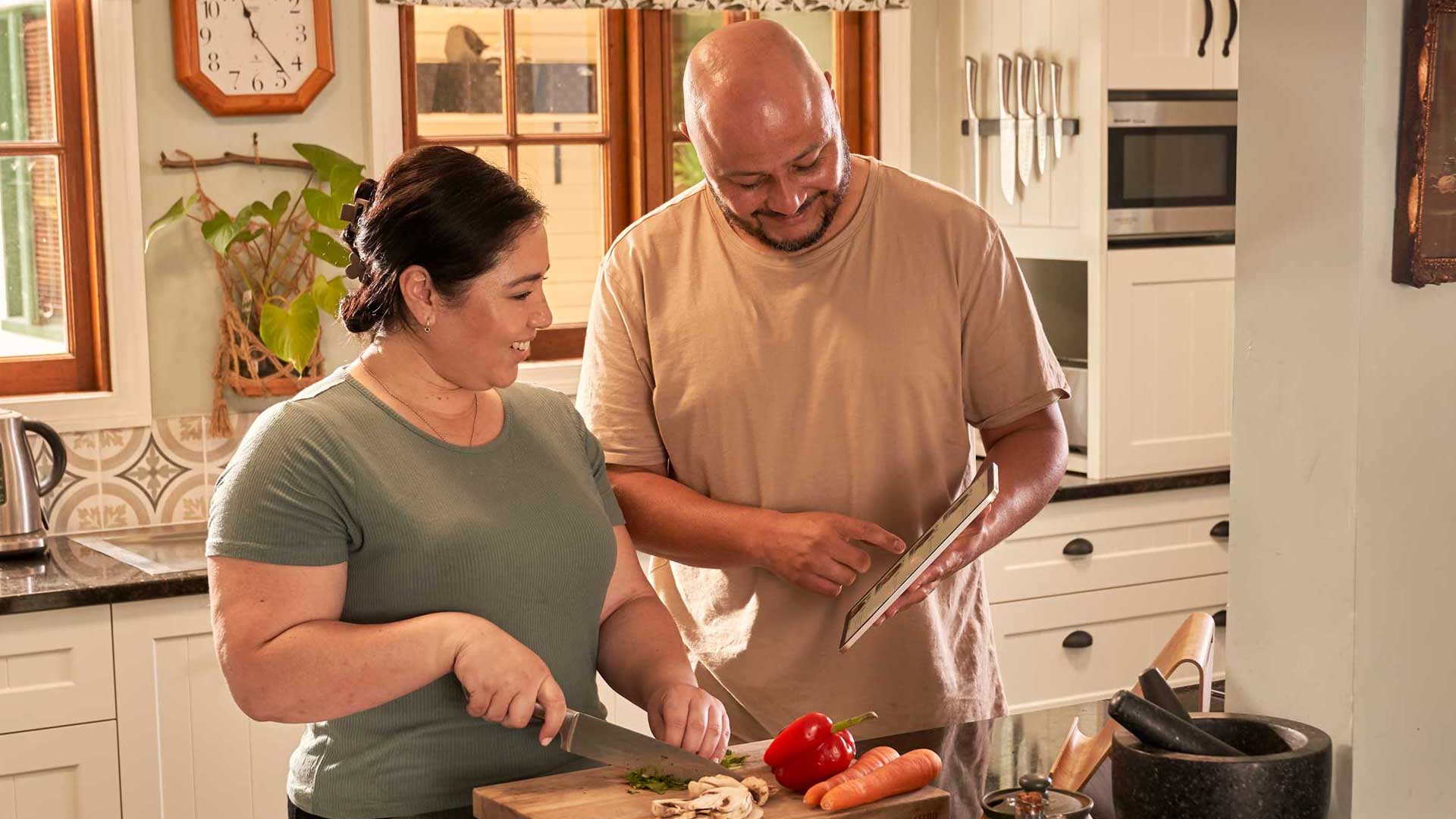 Couple cooking together in their kitchen, prepping food for healthy eating