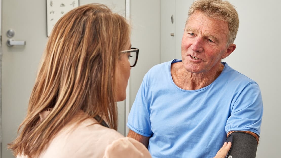 Male patient with female GP getting blood pressure taken