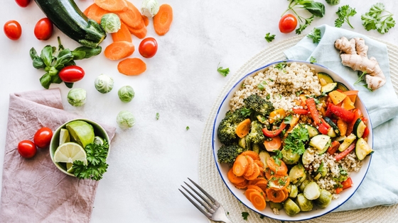 A plate of vegetables and rice with a fork and knife, a healthy and balanced meal option.