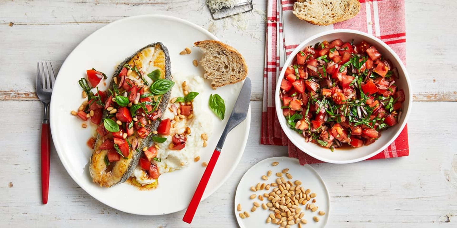 Two plates with a variety of fish and vegetables beautifully arranged on them, creating a colorful and appetizing meal