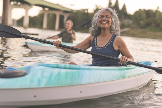 A couple paddling a kayak on calm waters, enjoying a serene outdoor adventure together.
