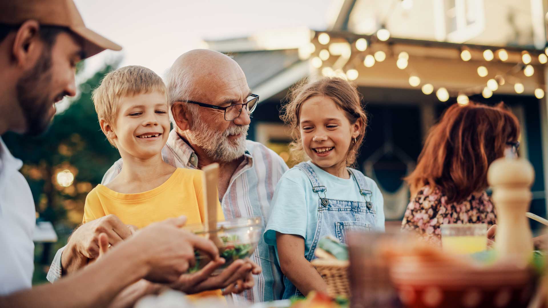 Mature grandfather with his grandchildren and other family members